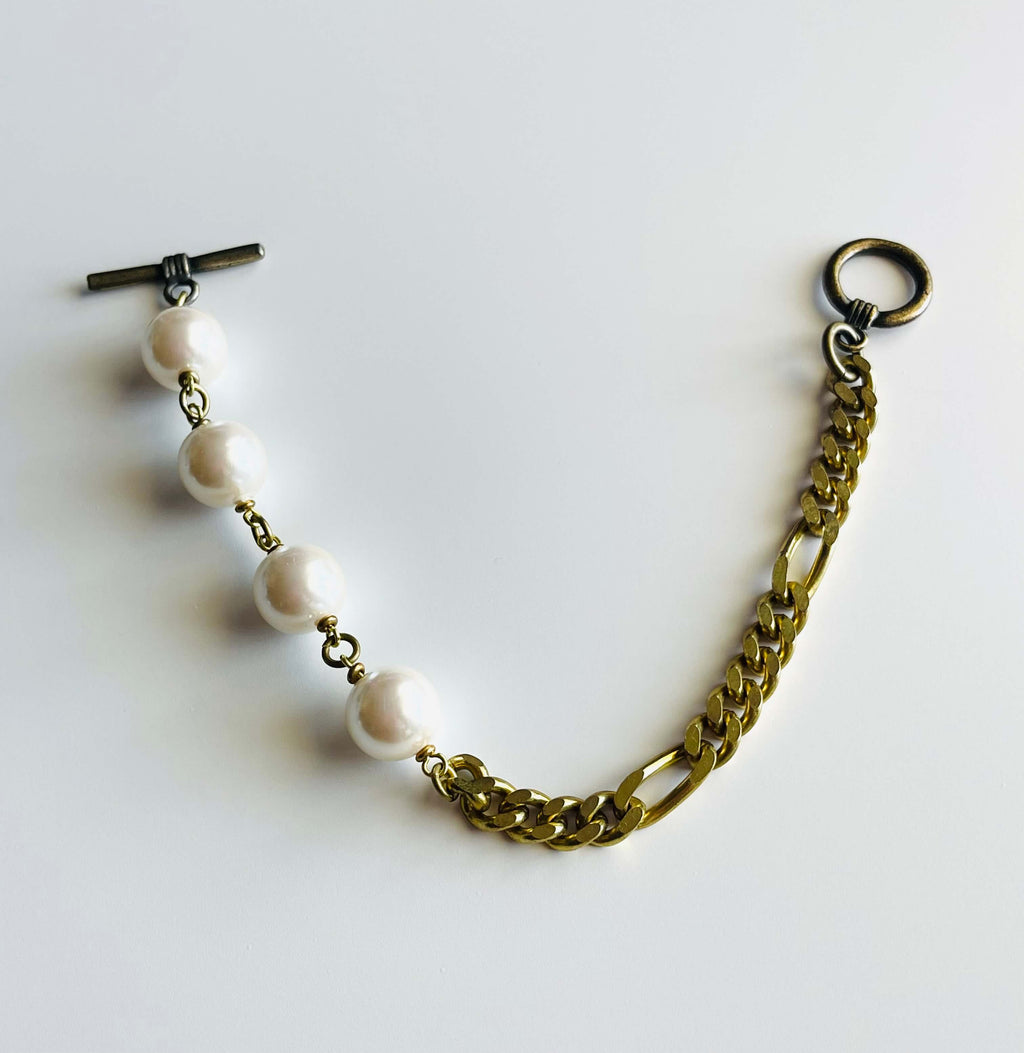 yellow brass and white pearl bracelet on white background 