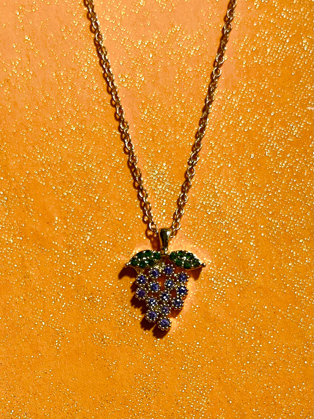 Grape charm on chain with yellow background 