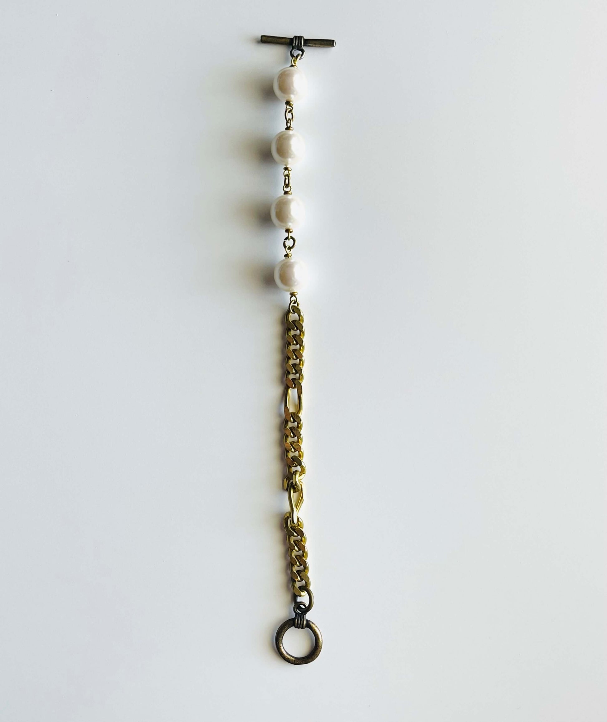 Yellow brass and white pearl bracelet on white background 