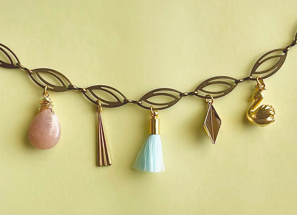 Necklace with various charms on a yellow background