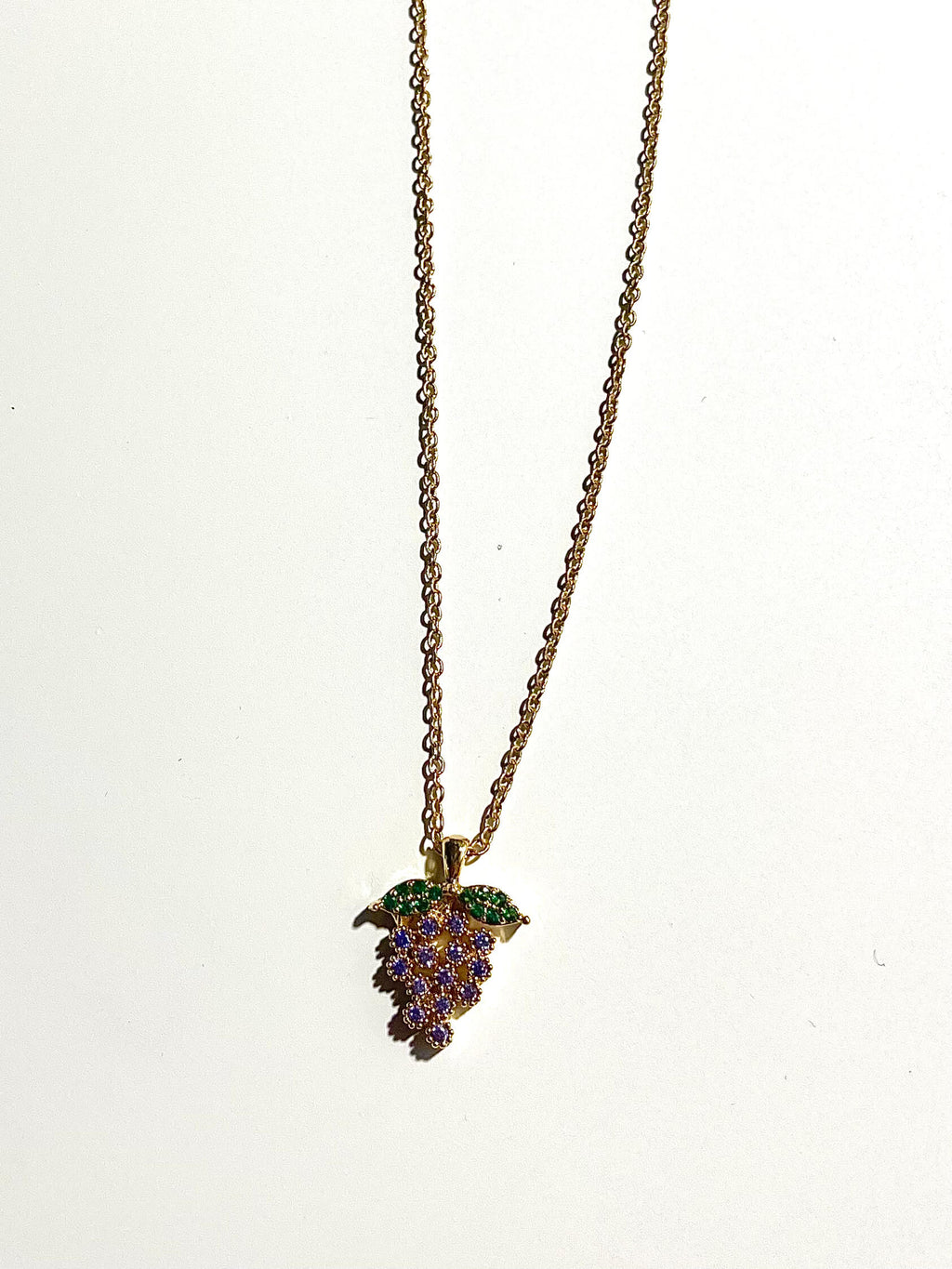 Crystal grape charm on a vintage chain with white background 